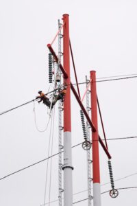 Two Linemen working high in the air on a transmission line.